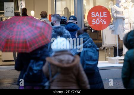15 décembre 2020, Rhénanie-du-Nord-Westphalie, Cologne : les clients attendent à l'extérieur d'un magasin de vêtements pour y entrer. Le dernier jour avant le verrouillage, beaucoup veulent encore acheter un cadeau de Noël. Photo: Henning Kaiser/dpa Banque D'Images