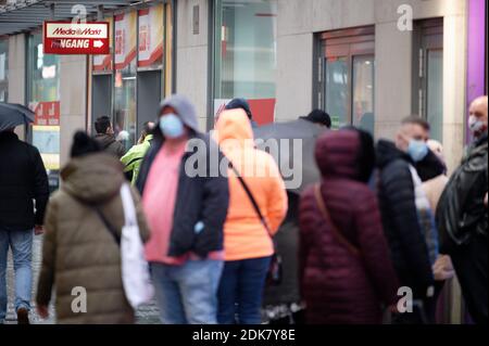15 décembre 2020, Rhénanie-du-Nord-Westphalie, Cologne : les clients attendent à l'extérieur d'un magasin d'électronique pour y accéder. Le dernier jour avant le verrouillage, de nombreux acheteurs veulent encore acheter un cadeau de Noël. Photo: Henning Kaiser/dpa Banque D'Images