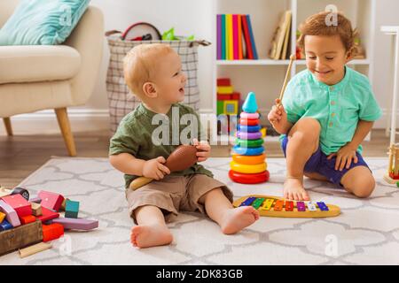 Les petits garçons jouent avec des jouets musicaux dans la maternelle Banque D'Images