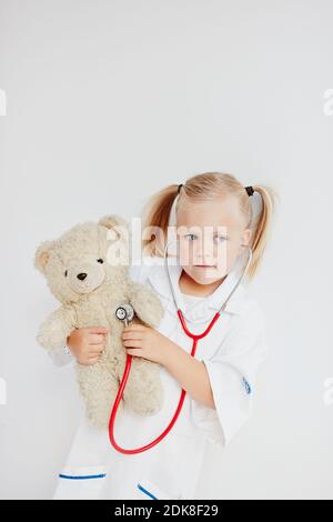 Girl playing doctor avec ours Banque D'Images
