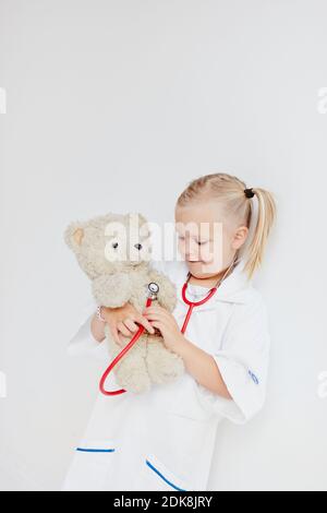Girl playing doctor avec ours Banque D'Images