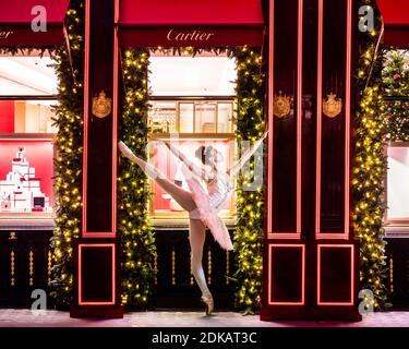 Une danseuse de ballet Nutcracker de Sugar Plum Fairy se produit devant la vitrine de la boutique Cartier sur Old Bond St, Londres Banque D'Images