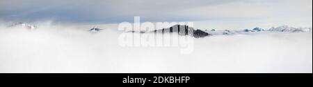 Hiver vue panoramique sur les montagnes enneigées au-dessus des nuages de brouillard d'inversion. Vue de Riedberger Horn à Allgau, Bavière, Allemagne. Banque D'Images