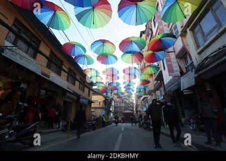 15 décembre 2020, Katmandou, Bagmati, Népal: Les gens marchent à côté des parasols colorés placés le long de la rue pour produire le sentiment de ''Parapluie Street'' à Newroad à Katmandou, Népal le 15,2020 décembre. (Image crédit : © Sunil Sharma/ZUMA Wire) Banque D'Images