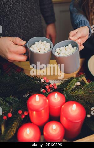 Homemade two Cocoa glasses with Marshmallows. Hot winter drink on wooden Backdrop decorated with cinamon sticks and fir branches Banque D'Images