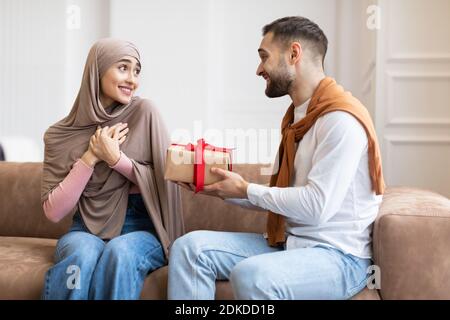 Un mari musulman donne une boîte cadeau à une femme surprise à la maison Banque D'Images