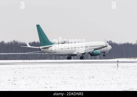 Décollage de l'avion de l'aéroport couvert de neige par mauvais temps pendant une tempête de neige, un vent fort en hiver Banque D'Images