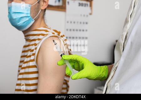 L'homme reçoit un jab, l'homme se vaccine. Les parents obtiennent un vaccin contre le covid-19 de deuxième génération Banque D'Images