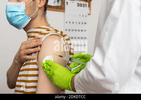 L'homme reçoit un jab, l'homme se vaccine. Les parents obtiennent un vaccin contre le covid-19 de deuxième génération Banque D'Images