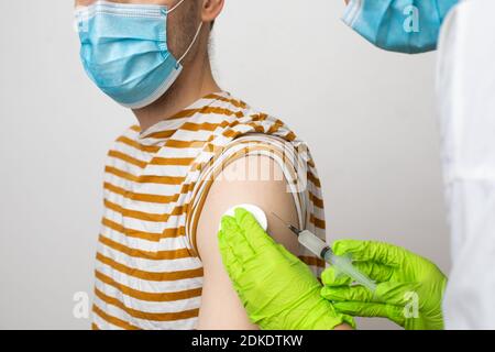 L'homme reçoit un jab, l'homme se vaccine. Les parents obtiennent un vaccin contre le covid-19 de deuxième génération Banque D'Images