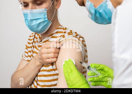 L'homme reçoit un jab, l'homme se vaccine. Les parents obtiennent un vaccin contre le covid-19 de deuxième génération Banque D'Images