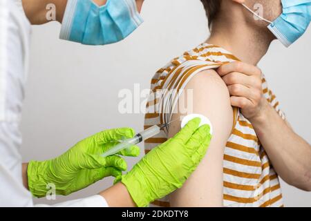 L'homme reçoit un jab, l'homme se vaccine. Les parents obtiennent un vaccin contre le covid-19 de deuxième génération Banque D'Images