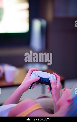 Moscou - novembre 28 2020 : une femme tient à la maison la manette de commande Dualsense de la console de jeu PlayStation 5 de Sony. Jouer avec elle Banque D'Images