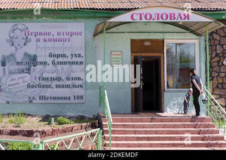 Une mère et un fils se tiennent sur le porche d'une salle à manger du village lors d'une journée d'été ensoleillée dans le village de Shira. Khakassia. Russie. Banque D'Images