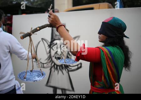 15 décembre 2020 : un artiste de la performance agissant comme la statue de la justice de la dame est debout devant un protrait d'un homme radical musulman qui est représenté par un artiste. Crédit: Md Rakibul Hasan/ZUMA Wire/Alay Live News Banque D'Images