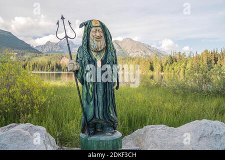 Statue de Waterman au bord du lac de montagne dans le parc national de High Tatras. Strbske pleso, Slovaquie, Europe. Soirée en fin d'été au bord du lac. Banque D'Images