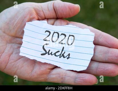 Papernote in hand.2020 sucks. Stock Photo