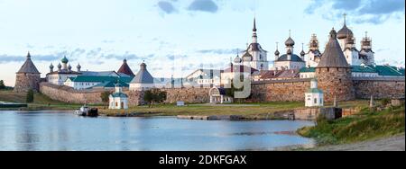 Panorama du monastère Solovetsky avec baie bleue en premier plan au coucher du soleil, temples, tours, mur environnant sur l'île de Bolchoy Solovetsky, Ru Banque D'Images