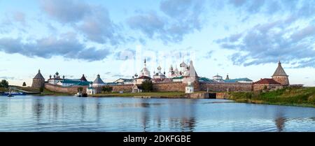 Panorama du monastère Solovetsky avec baie bleue en premier plan au coucher du soleil, temples, tours, mur environnant sur l'île de Bolchoy Solovetsky, Ru Banque D'Images