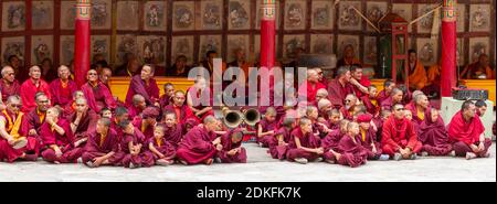 Hemis, Inde - 29 juin 2012 : moines Gelug-pa, bonzes, batteurs rituels et trompettistes avec instruments de musique comme spectateurs attentifs à t Banque D'Images