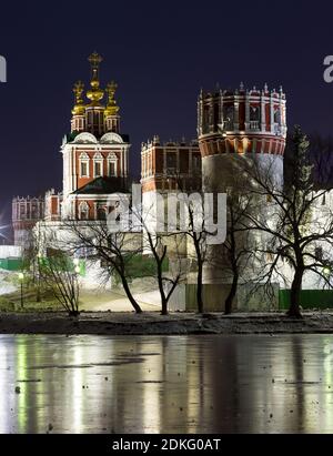 Vue nocturne du couvent de Novodevichy - site classé au patrimoine mondial de l'UNESCO - en hiver : l'église de la Transfiguration au-dessus de la porte nord Banque D'Images