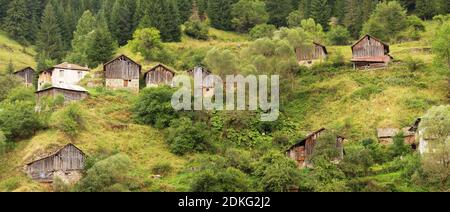 Dépendances de campagne (hangars) dans la forêt de conifères sur les pentes abruptes des montagnes Rhodope par temps nuageux (Rhodopes, Bulgarie) Banque D'Images