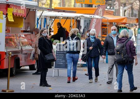Duisburg, Rhénanie-du-Nord-Westphalie, Allemagne - exigence de masque dans le centre-ville de Duisburg en temps de crise de la couronne pendant la deuxième partie du confinement, les passants avec des masques de protection traversent le marché hebdomadaire sur Koenigstrasse, la principale rue commerçante de la zone piétonne. Banque D'Images