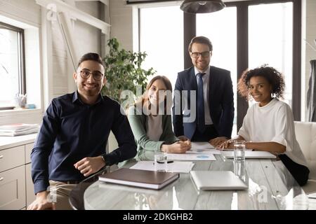 Portrait de collègues multiraciaux souriants posant dans la salle de réunion du bureau Banque D'Images