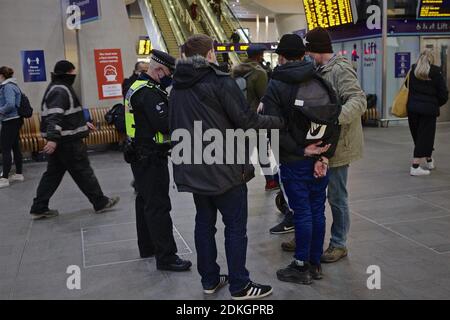 Londres (Royaume-Uni), 15 décembre 2020 : menottage de la police britannique des transports et recherche un homme à la gare de London Bridge avant de le conduire. Banque D'Images