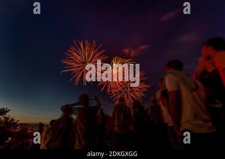 Un groupe de personnes observe un impressionnant feu d'artifice au ciel nocturne de Munich Banque D'Images