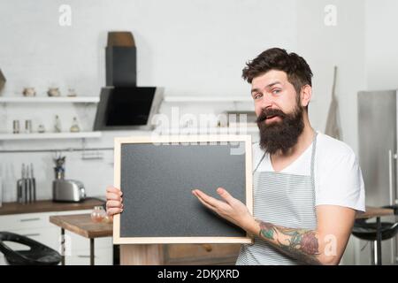 un barista souriant tient un tableau vierge pour l'espace de texte. un homme barbu présente le produit. bienvenue à bord. annonce et publicité. meilleure offre ici. homme d'affaires mature. Banque D'Images