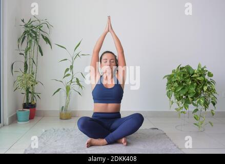 Jeune femme faisant du yoga sur le sol à la maison