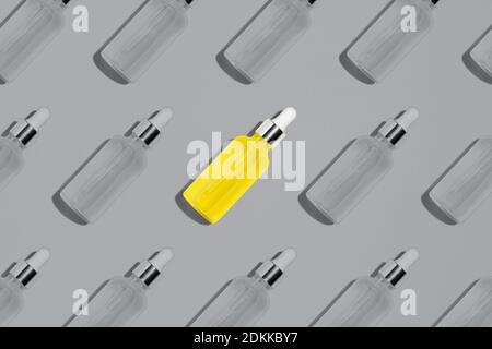 Motif de bouteille de sérum en verre jaune illuminant sur fond gris ultime. Maquette de pipette à usage cosmétique. Couleurs créatives de l'année 2021 Banque D'Images