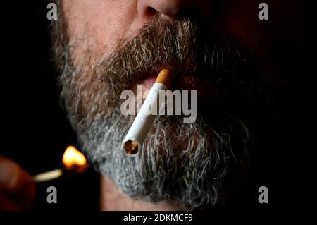 Marseille, France. 14 décembre 2020. Dans cette illustration, un homme allume une cigarette.comme le prévoit le gouvernement français, le prix moyen d'un paquet de cigarettes sera de 10 cents plus cher. La décision a été prise dans l'espoir de réduire le nombre de fumeurs en France. Crédit : SOPA Images Limited/Alamy Live News Banque D'Images