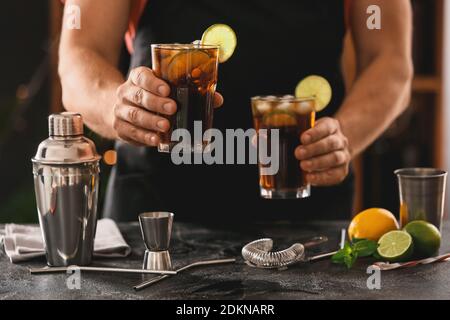 Barman préparer un cocktail Cuba libre avec du citron vert et de la glace Banque D'Images