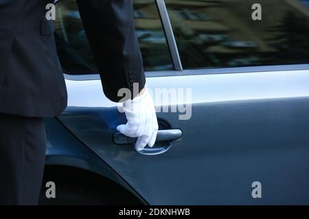 Chauffeur ouvrant la porte de la voiture de luxe Banque D'Images