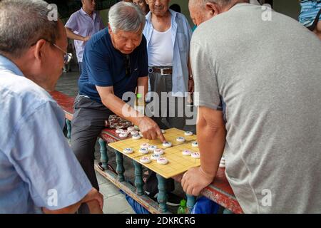 Les hommes plus âgés jouant au jeu des Dames chinoises traditionnelles dans les jardins de Temple du ciel de Pékin Banque D'Images