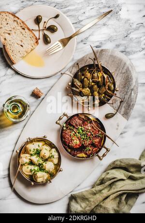 Plats de différentes meze méditerranéenne végétarienne dans des plats de cuivre, huile d'olive et pain frais sur fond de table en marbre, vue du dessus. Concept de cuisine égéenne Banque D'Images