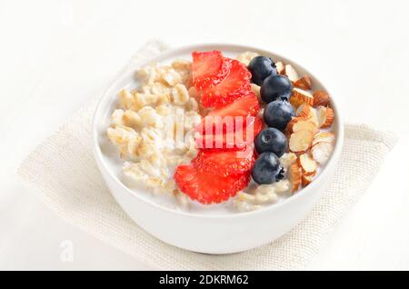 Porridge de flocons d'avoine avec fraise, bleuets et noix dans un bol Banque D'Images