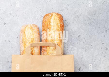 Pain de baguette dans un sac en papier. Vue de dessus du plan de travail avec espace de copie Banque D'Images