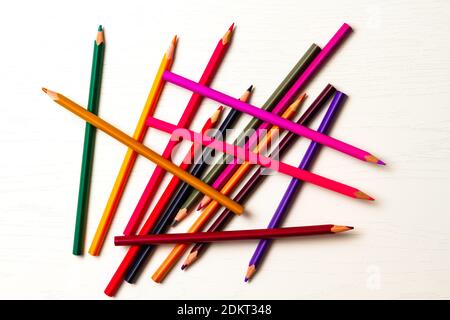 de nombreux crayons de couleur aiguisés se trouvent sur une table en bois blanc Banque D'Images