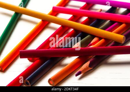 de nombreux crayons de couleur aiguisés se trouvent sur une table en bois blanc Banque D'Images