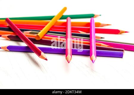 de nombreux crayons de couleur aiguisés se trouvent sur une table en bois blanc Banque D'Images