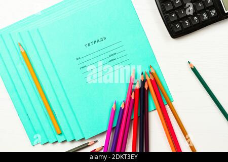 les crayons de couleur et les carnets de journal sont sur un bois blanc carnet de lettrage de table pour un élève de classe scolaire 12 feuilles Banque D'Images