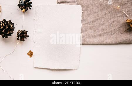 Pose plate style hygge. Liste de souhaits de Noël. Papier fait à la main noué avec des fils artisanaux. Enveloppe maquette de lettre, cônes de pin, fil d'artisanat. Banque D'Images