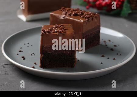 Brownie au chocolat avec confit à la framboise et mousse au café recouvert de glaçage au chocolat gourmet sur fond gris foncé. Gros plan. Banque D'Images