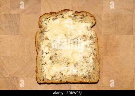 Pain coupé en tranches et beurre qui a des avantages pour la santé du petit déjeuner sur une photo de planche à découper en bois Banque D'Images