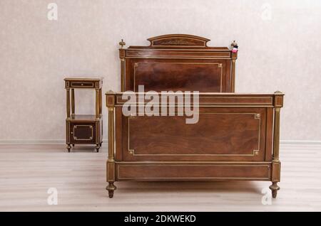 Antique vintage bedroom furniture: antique bed and bed table. Western Europe. Early 20th century Stock Photo