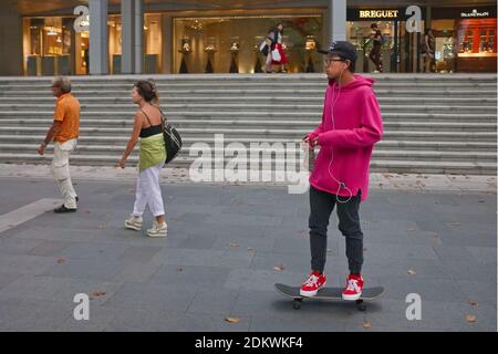 Un jeune Singapourien fait du skateboard le long de la rue commerçante haut de gamme Orchard Road, à Singapour Banque D'Images