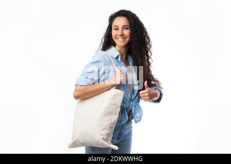 Femme portant un sac à bandoulière Eco en faisant des gestes sur fond blanc Banque D'Images